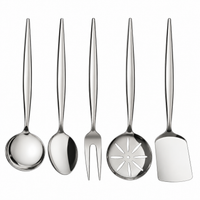 Five stainless steel kitchen utensils with long handles are arranged upright on a white marble countertop against a white subway tile backsplash. The utensils include a ladle, a spoon, a fork, a slotted serving spoon, and a spatula.
