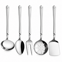 Five stainless steel kitchen utensils with long handles are arranged on a light marble countertop. The set includes a ladle, a spoon, a fork, a strainer, and a spatula.