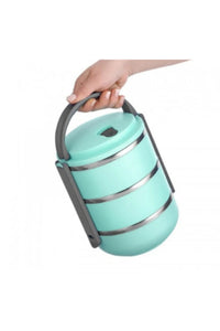 A mint green stackable lunch box with three tiers and a dark gray lid, set on a marble countertop