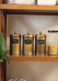 A set of three cylindrical gold-colored canisters with lids, labeled 'Coffee', 'Sugar', and 'Tea' respectively