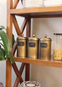 A set of three cylindrical gold-colored canisters with lids, labeled 'Coffee', 'Sugar', and 'Tea' respectively