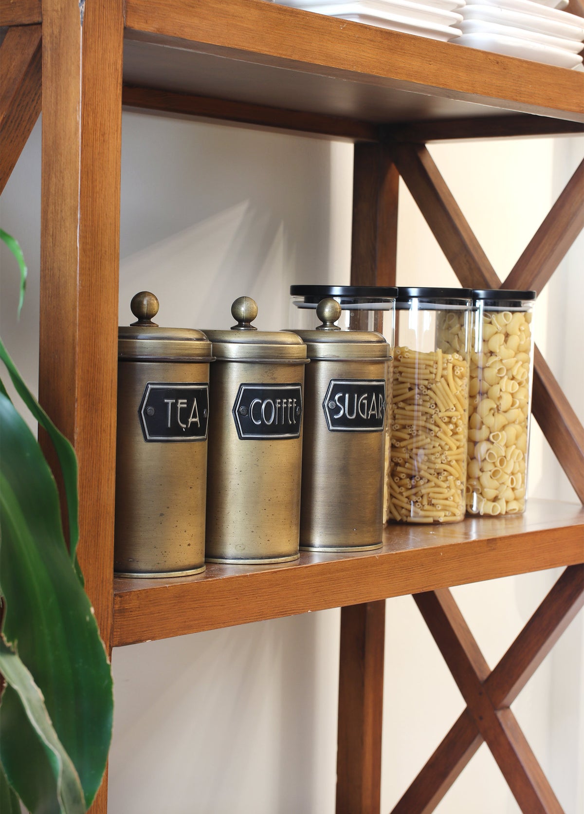 A set of three cylindrical gold-colored canisters with lids, labeled 'Coffee', 'Sugar', and 'Tea' respectively