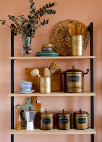 A gold cylindrical utensil holder with the word 'UTENSIL' embossed on the side.